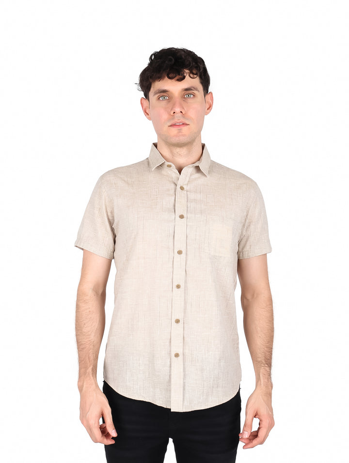 Hombre vistiendo una camisa de manga corta color beige con botones frontales.