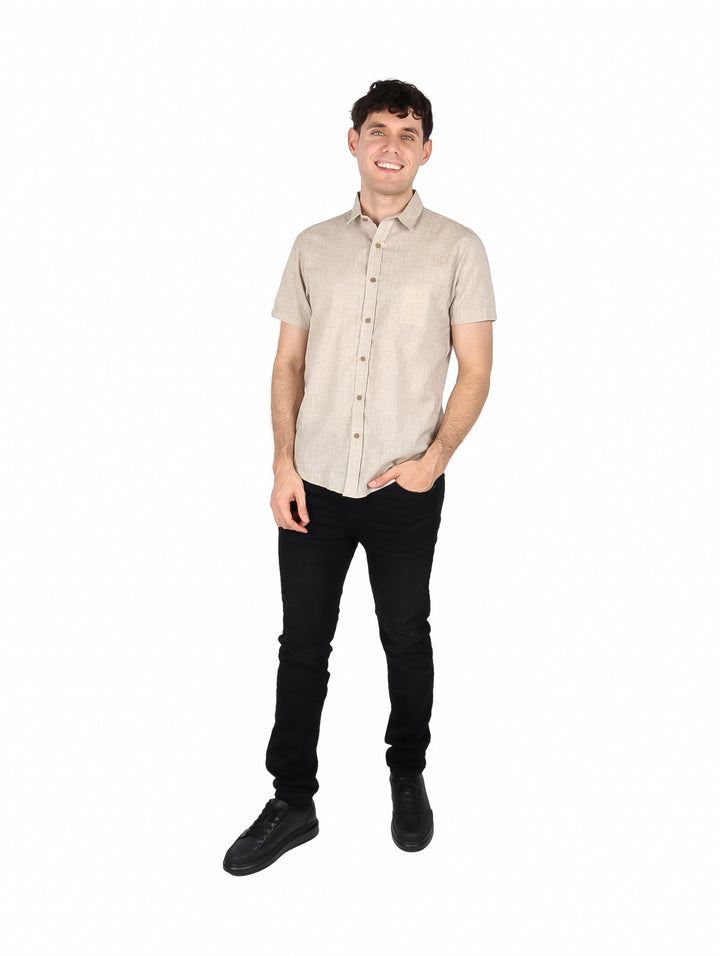 Hombre vistiendo una camisa de manga corta color beige con botones frontales.