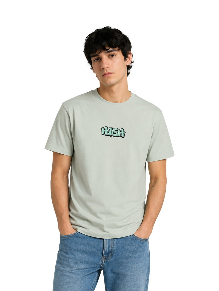 Hombre usando playera color verde claro de manga corta con estampado &