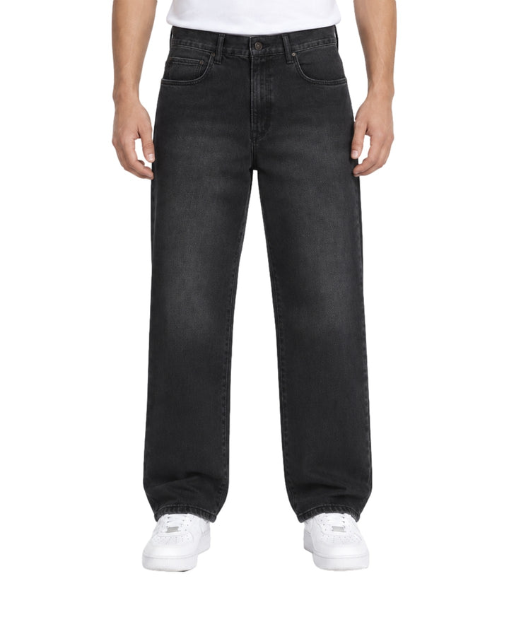 Hombre vistiendo jeans baggy color negro de la marca Furor con tenis blancos.