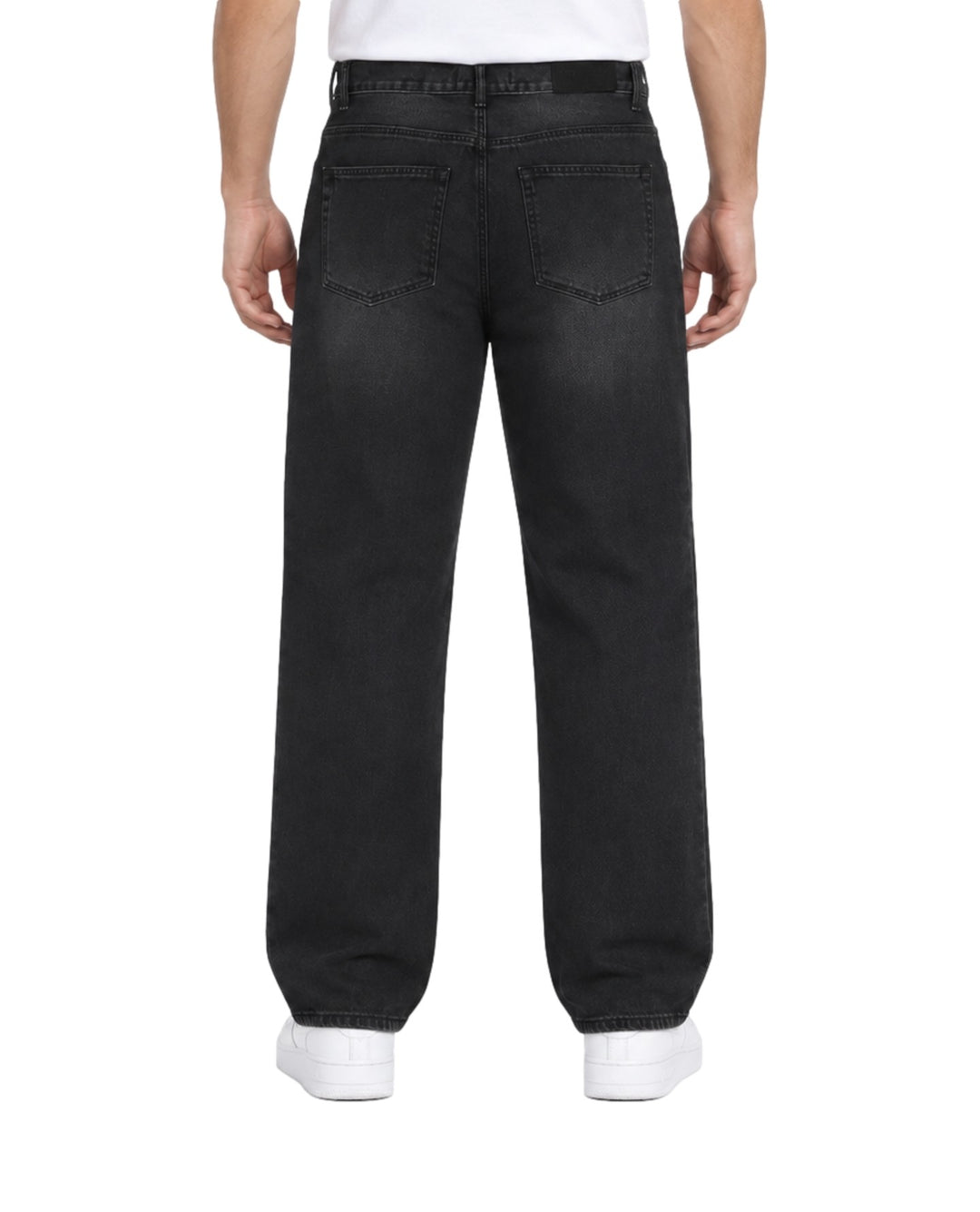 Hombre vistiendo jeans baggy color negro de la marca Furor con tenis blancos.