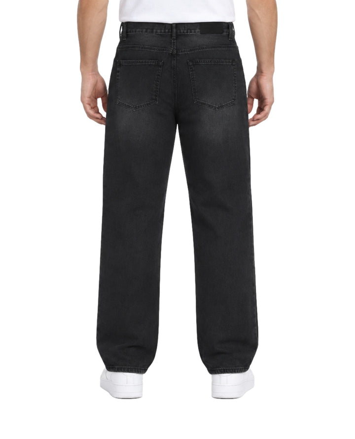 Hombre vistiendo jeans baggy color negro de la marca Furor con tenis blancos.