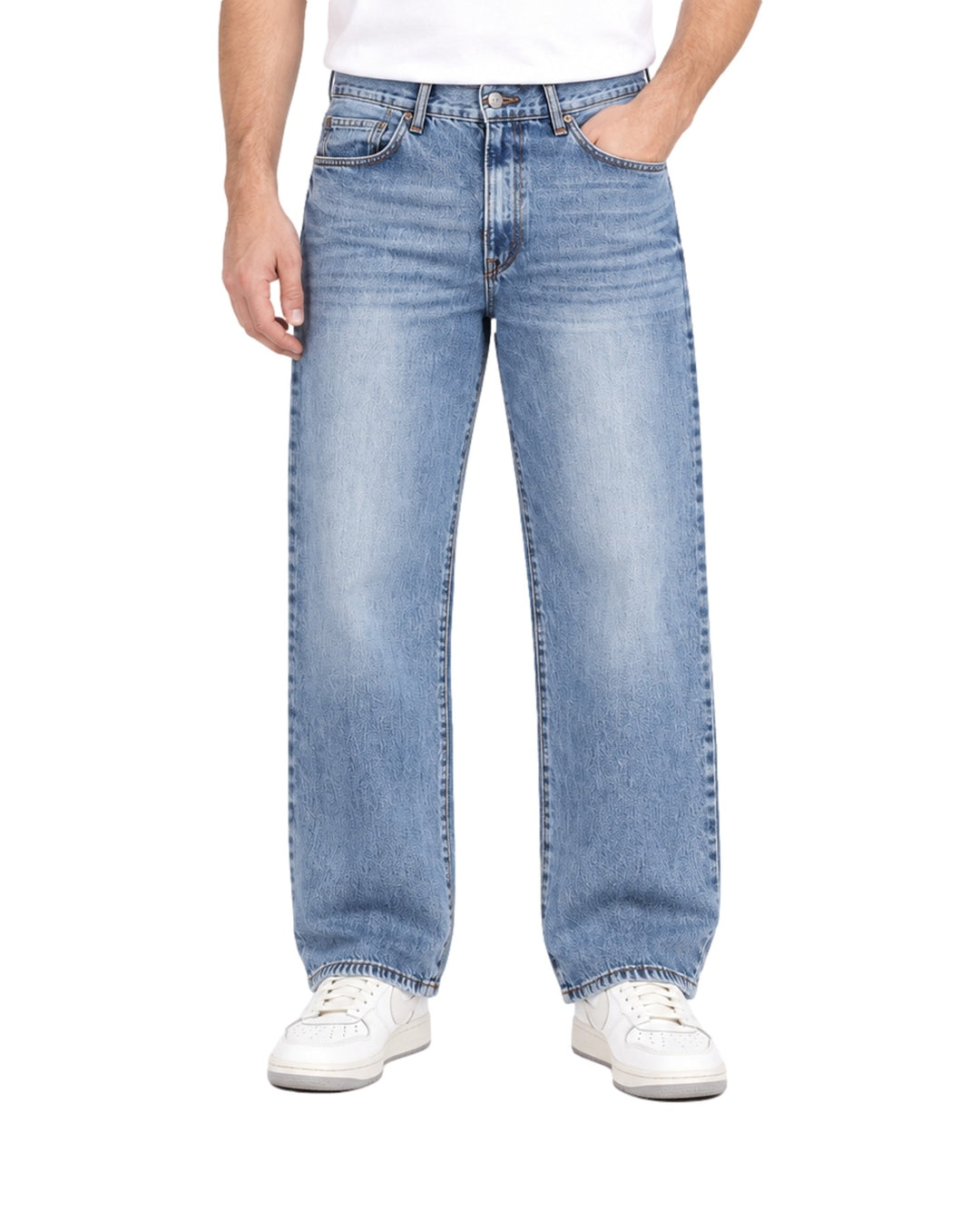 Hombre vistiendo jeans baggy color azul stone de corte ancho y calzado blanco.