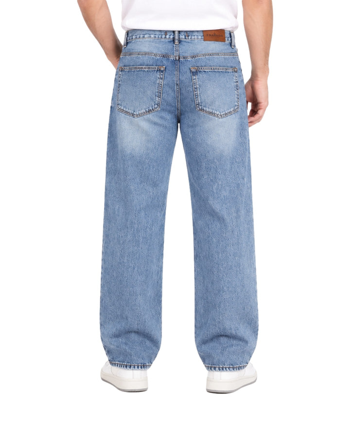Hombre vistiendo jeans baggy color azul stone de corte ancho y calzado blanco.