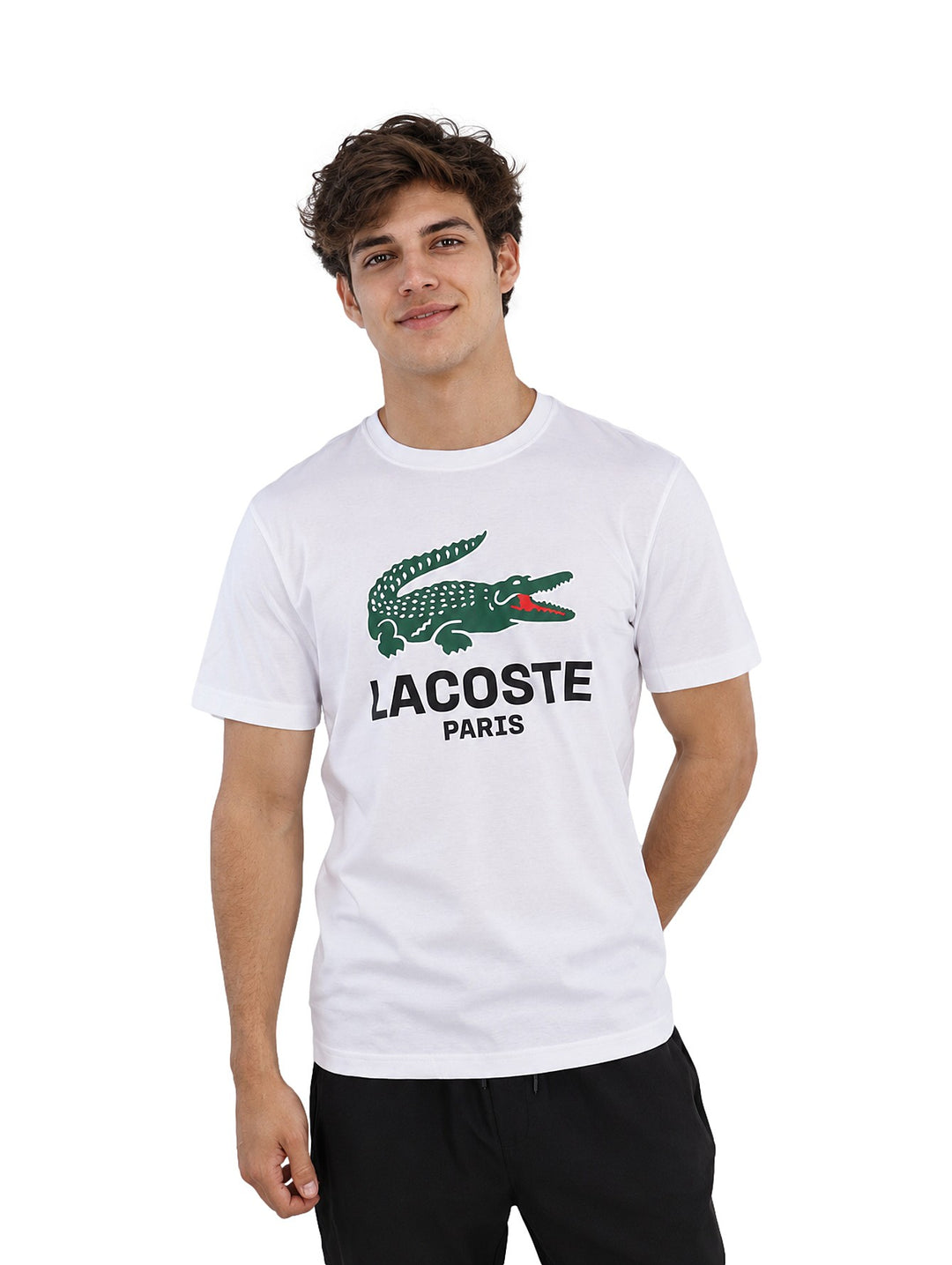 Hombre vistiendo playera blanca de manga corta con logotipo de Lacoste Paris en el pecho.