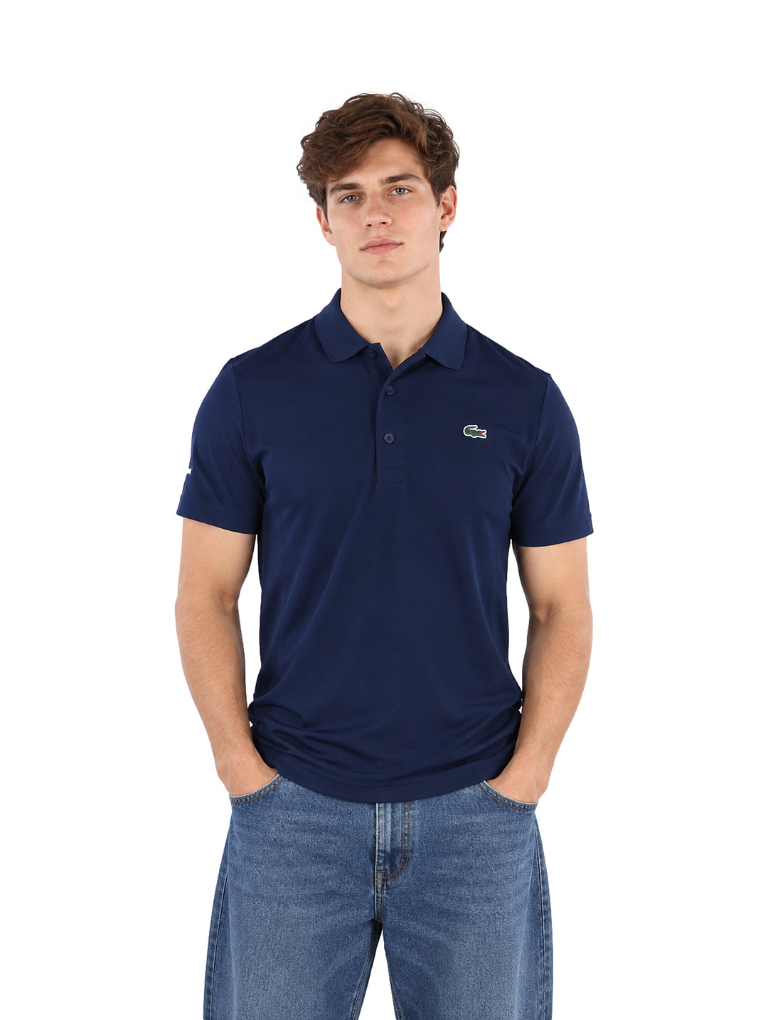 Hombre vistiendo una playera polo Lacoste color azul marino de manga corta.