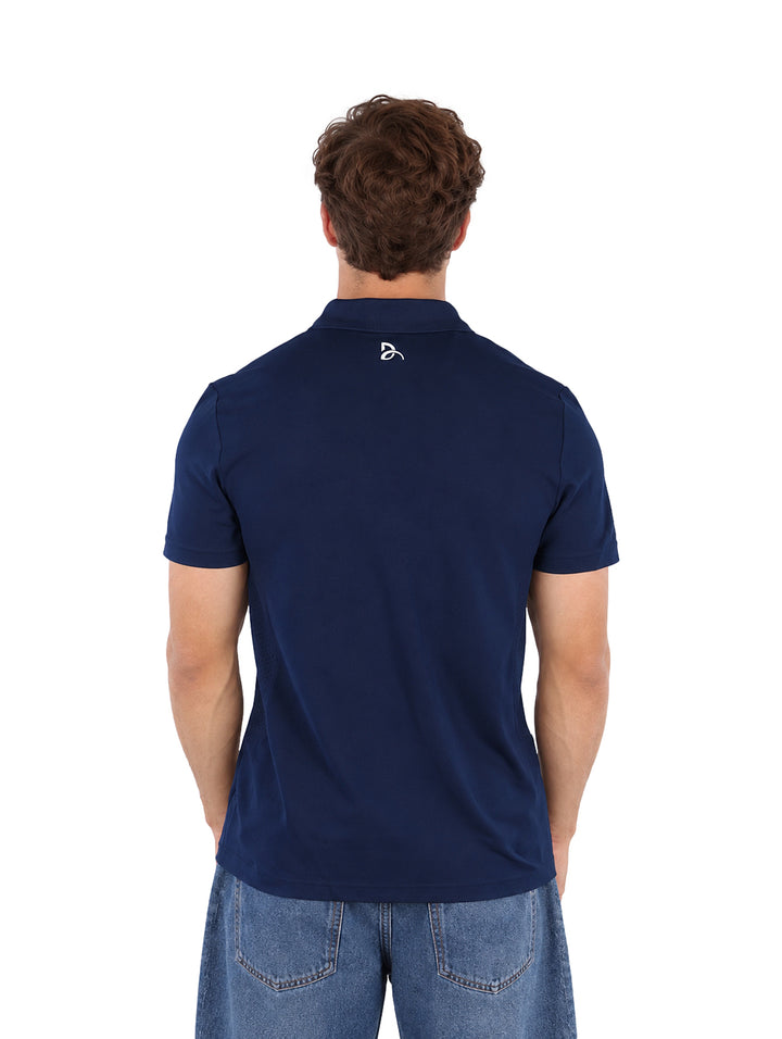 Hombre vistiendo una playera polo Lacoste color azul marino de manga corta.