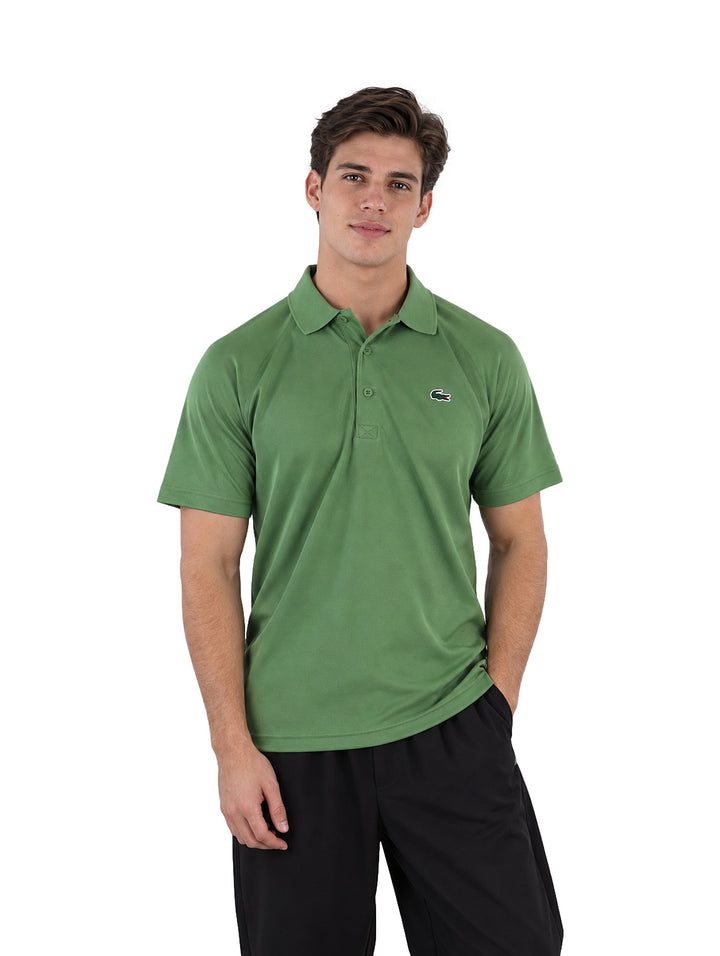 Hombre usando playera polo Lacoste color verde con cuello y manga corta.