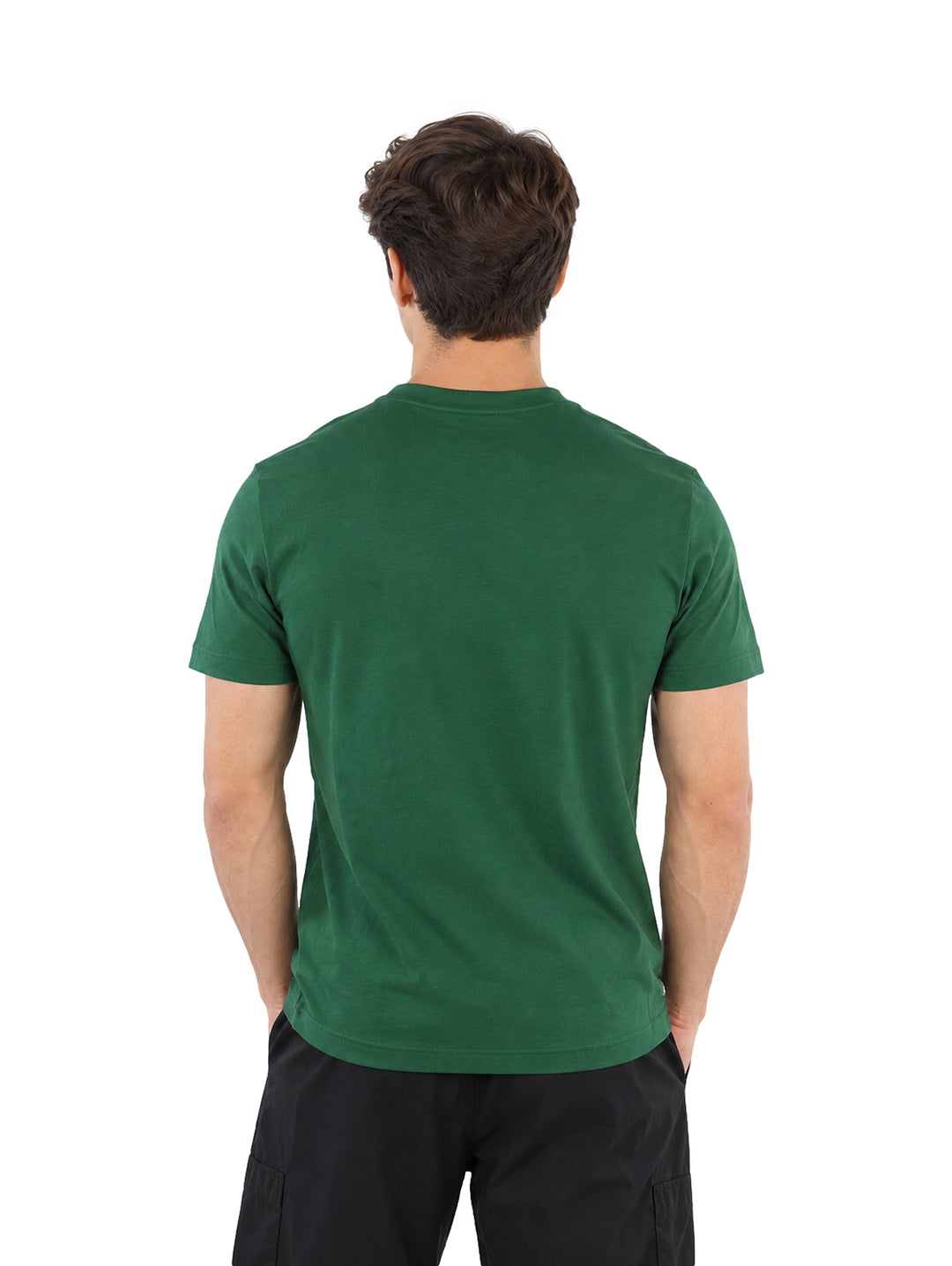 Hombre vistiendo playera Lacoste color verde de manga corta con texto frontal y shorts negros.