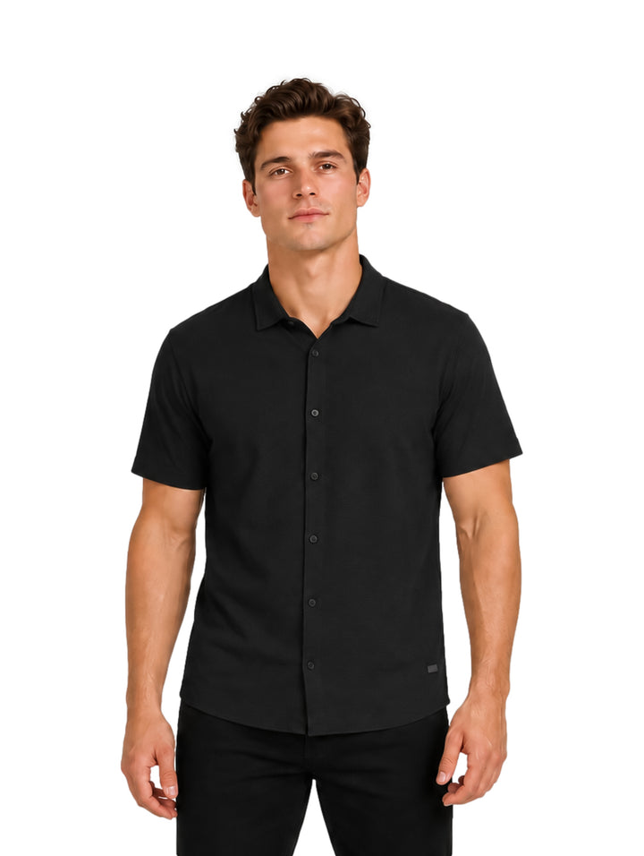 Hombre vistiendo una camisa de manga corta color negro de la marca Authentic Lyon.