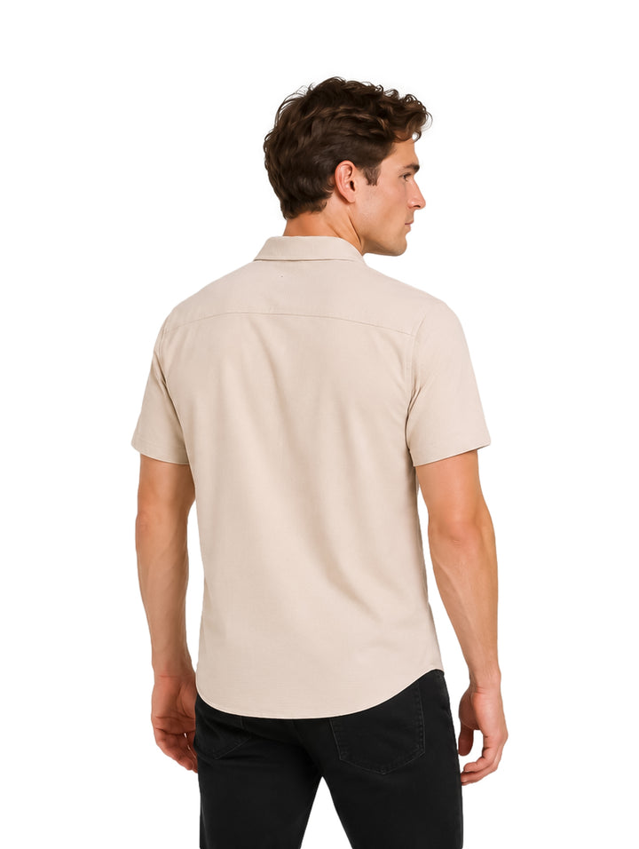 Hombre vistiendo una camisa de manga corta color beige con botones y cuello.