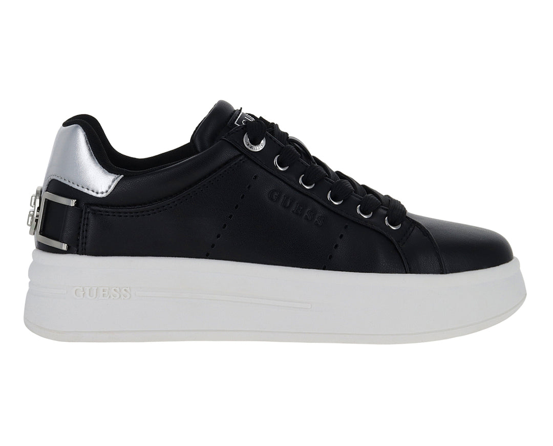 Tenis negros de plataforma con suela blanca y detalles plateados en el talón y correa.