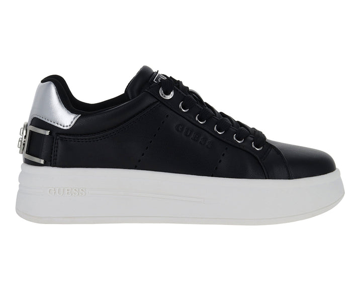 Tenis negros de plataforma con suela blanca y detalles plateados en el talón y correa.