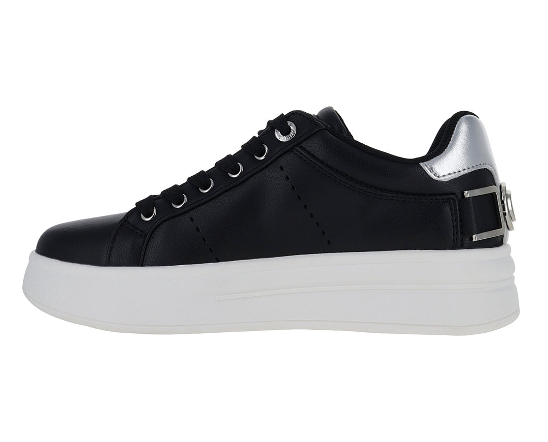 Tenis negros de plataforma con suela blanca y detalles plateados en el talón y correa.
