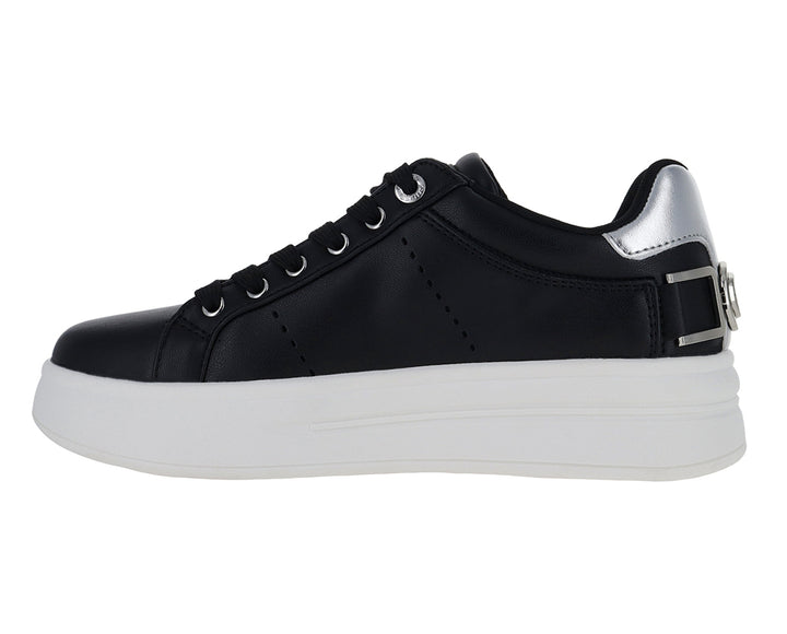 Tenis negros de plataforma con suela blanca y detalles plateados en el talón y correa.