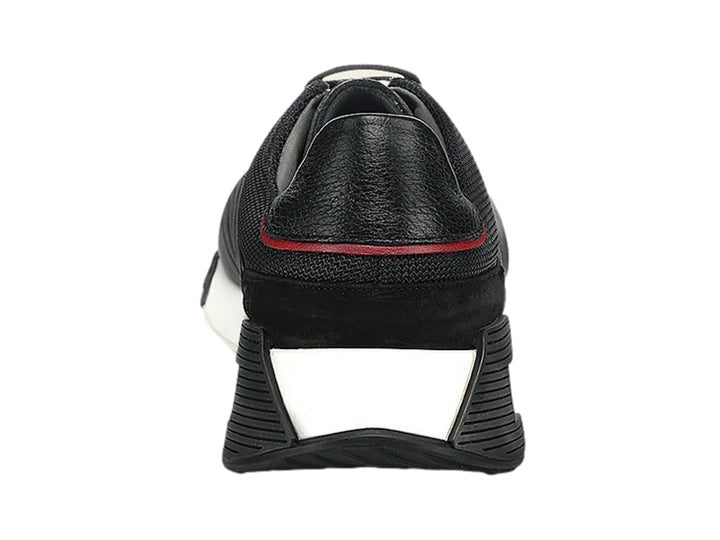Tenis Cuadra de cuero negro con suela blanca y detalles rojos, vista lateral.