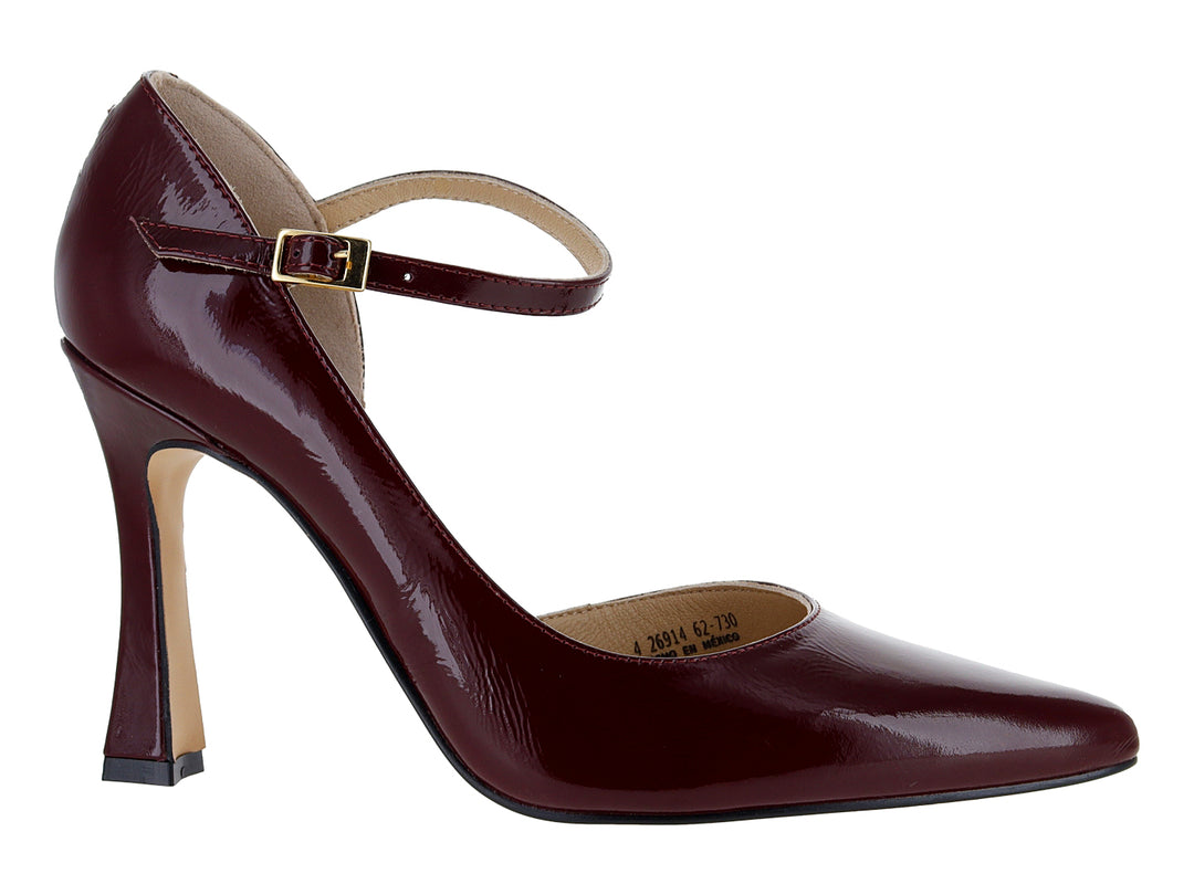Zapato de tacón cerrado color vino con acabado brillante y correa al tobillo con hebilla dorada.