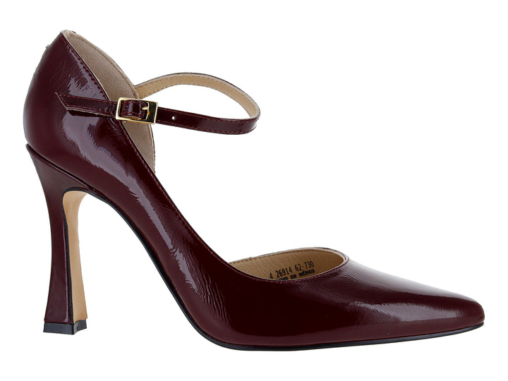 Zapato de tacón cerrado color vino con acabado brillante y correa al tobillo con hebilla dorada.