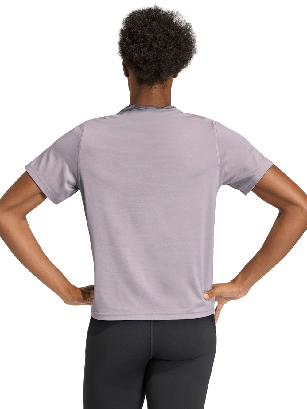 Mujer vistiendo una playera deportiva Adidas de color lila con logo blanco en el pecho.