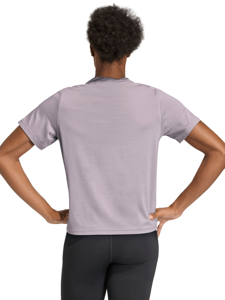 Mujer vistiendo una playera deportiva Adidas de color lila con logo blanco en el pecho.