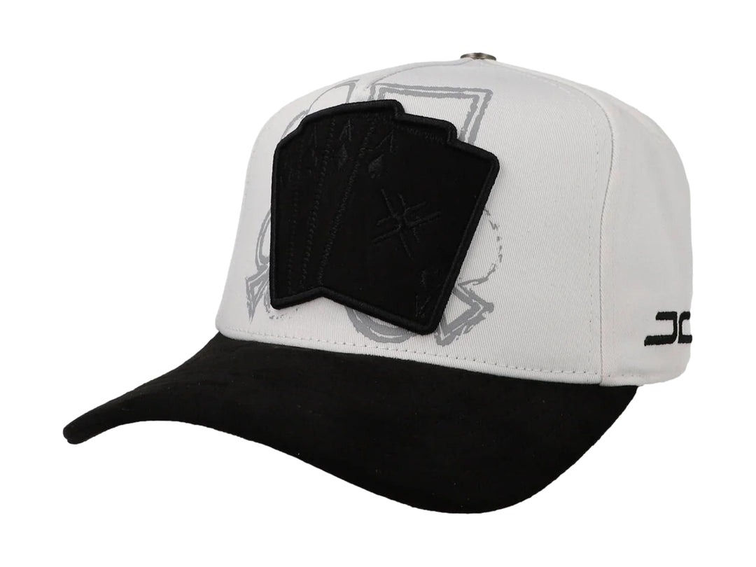 Gorra JC Hats blanca con visera negra y parche frontal con diseño de cartas de poker.