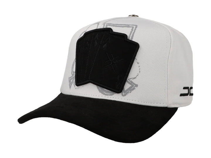 Gorra JC Hats blanca con visera negra y parche frontal con diseño de cartas de poker.