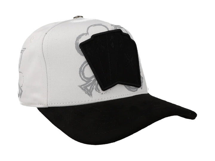 Gorra JC Hats blanca con visera negra y parche frontal con diseño de cartas de poker.