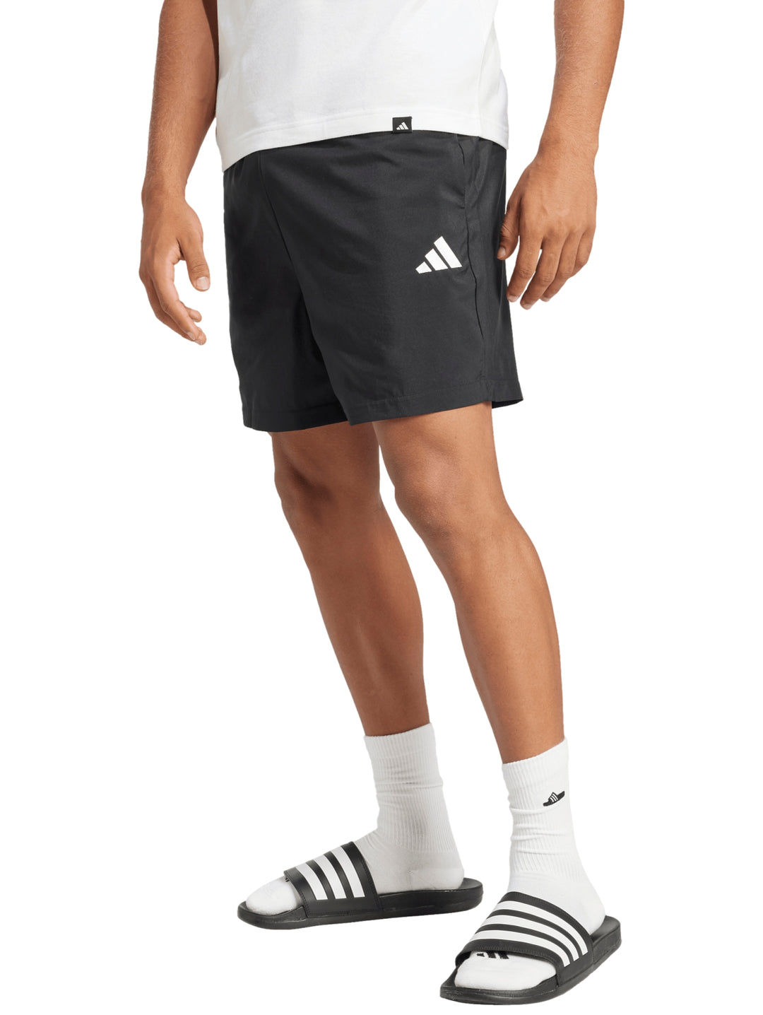 Hombre vistiendo shorts deportivos negros de la marca Adidas con logo blanco en la pierna.