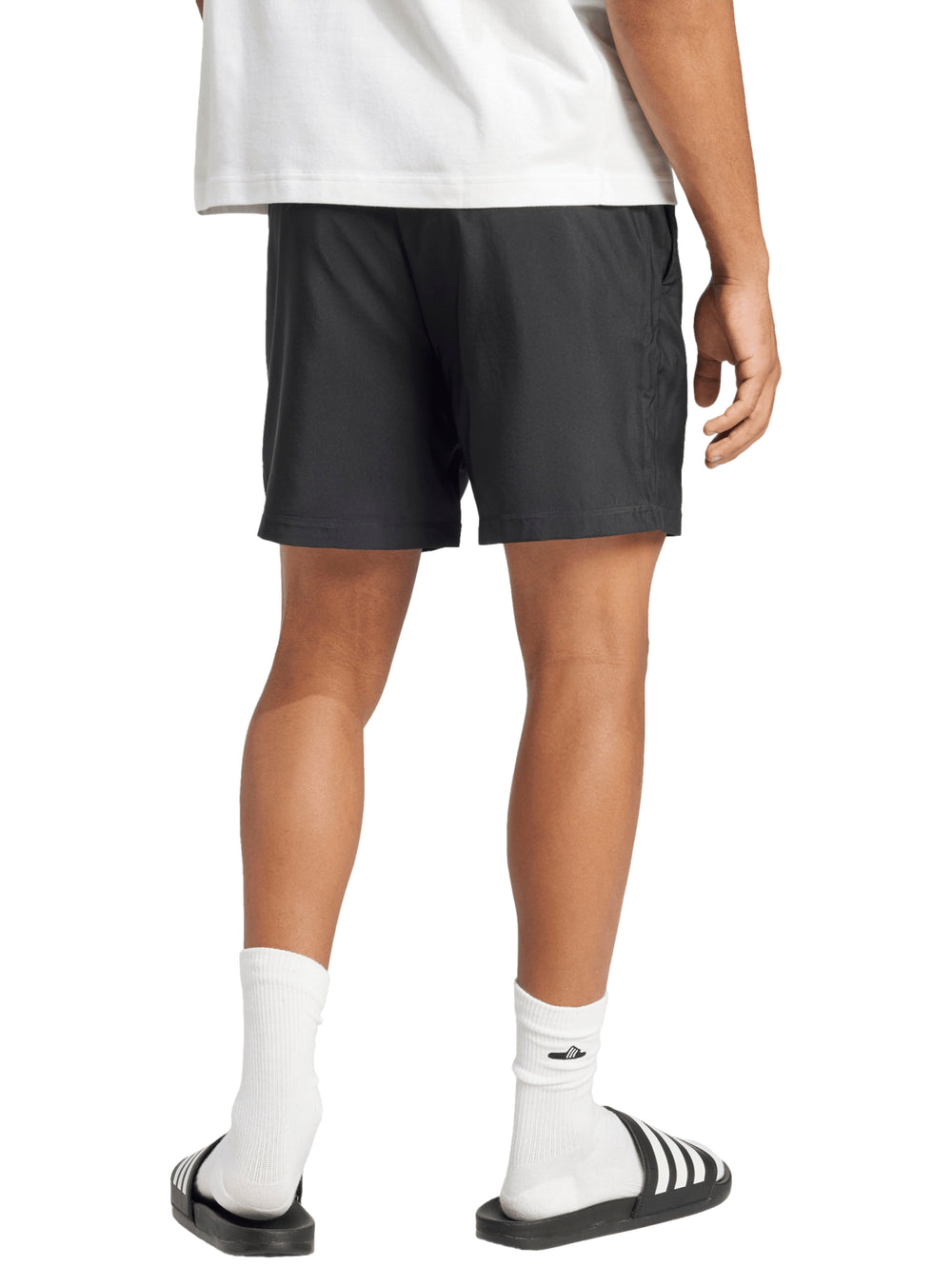 Hombre vistiendo shorts deportivos negros de la marca Adidas con logo blanco en la pierna.