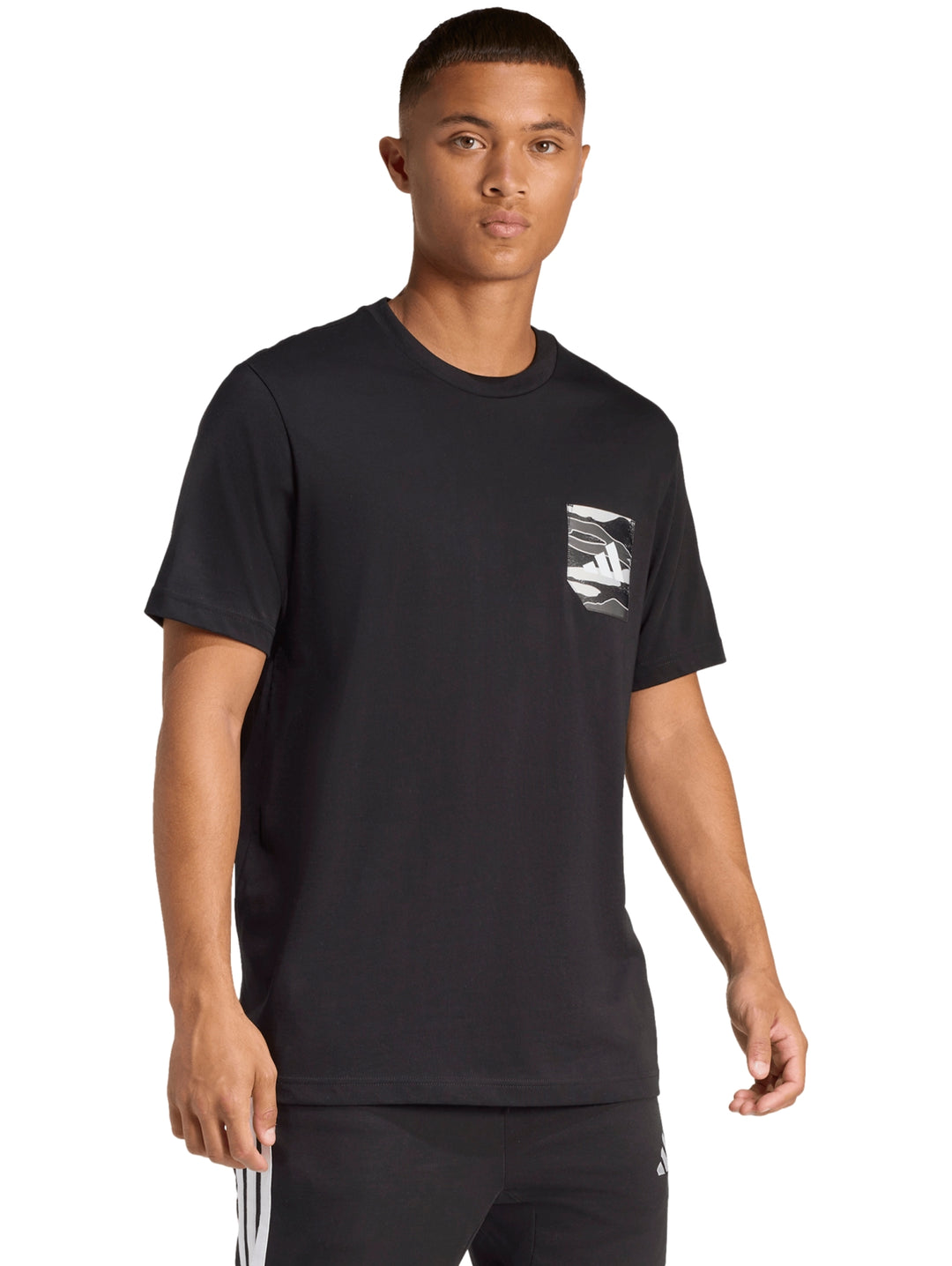 Hombre vistiendo una camiseta deportiva Adidas de color negro con un detalle gráfico en el pecho.