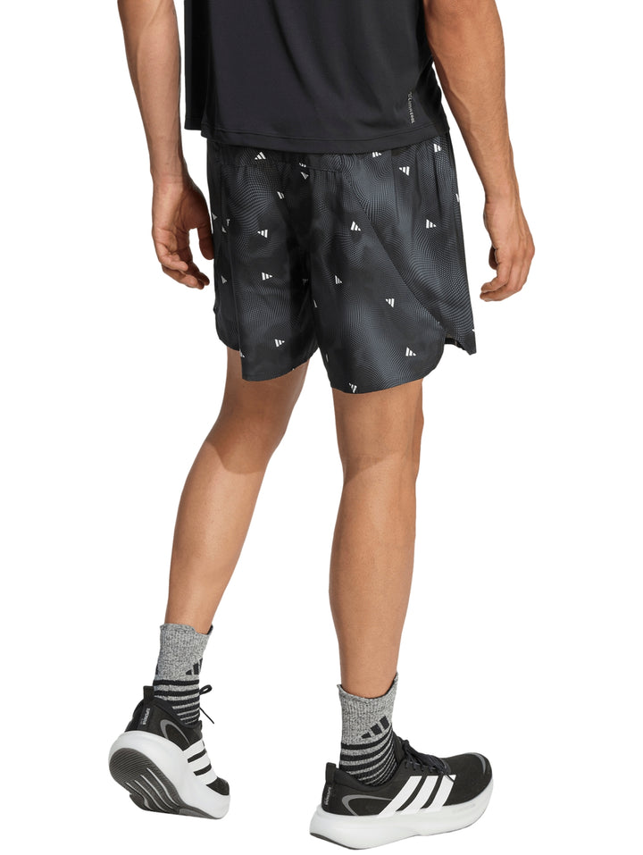 Hombre vistiendo shorts deportivos Adidas color negro con detalles blancos y estampado sutil.