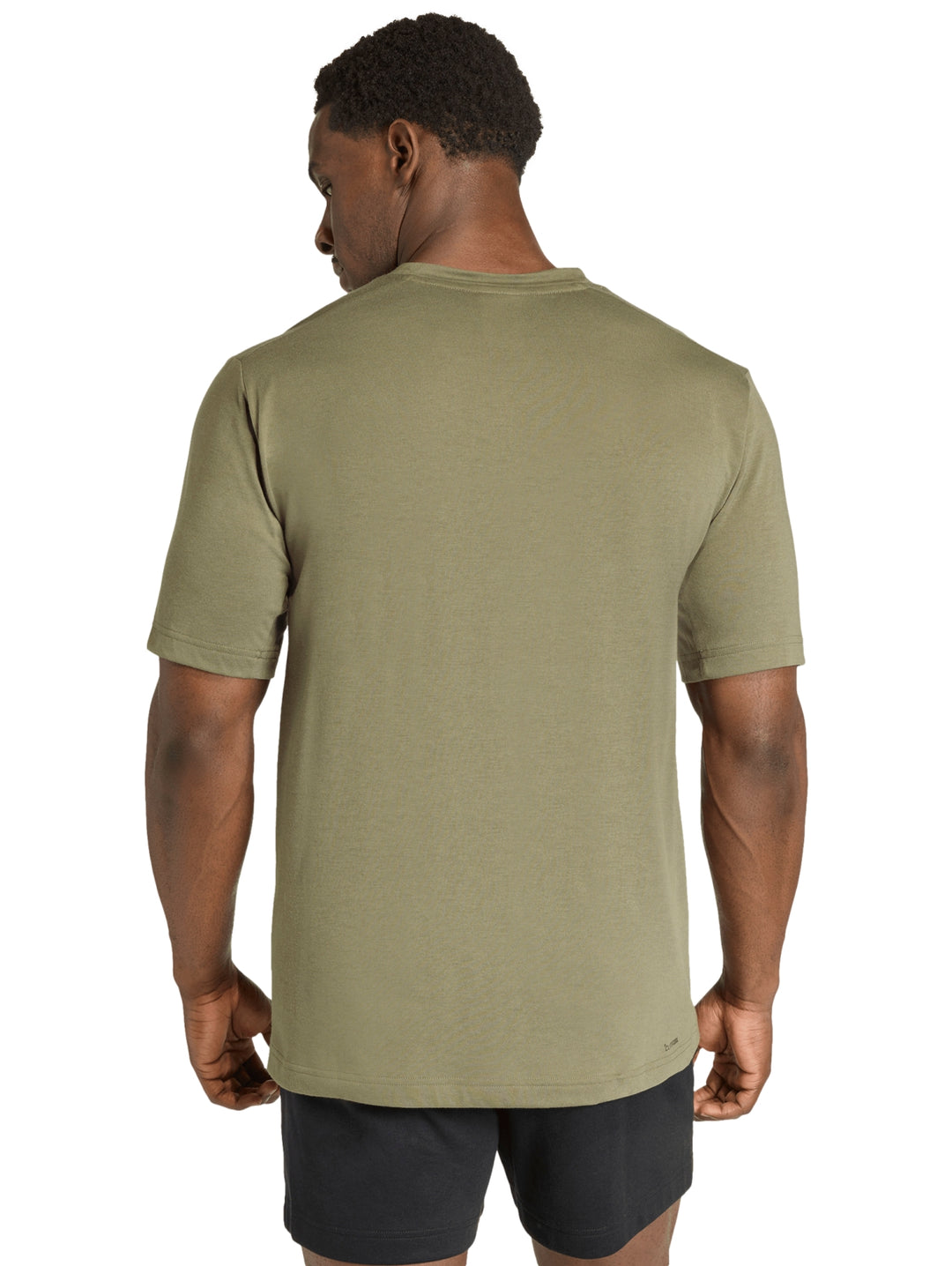 Hombre vistiendo una camiseta deportiva Adidas de color verde oliva con logo pequeño en el pecho.