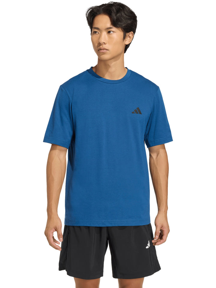 Hombre vistiendo una camiseta deportiva azul de manga corta con logo de Adidas en el pecho.
