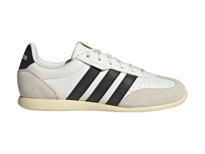 Tenis Adidas blancos con tres franjas negras y detalles en color crema en la punta y el talón.