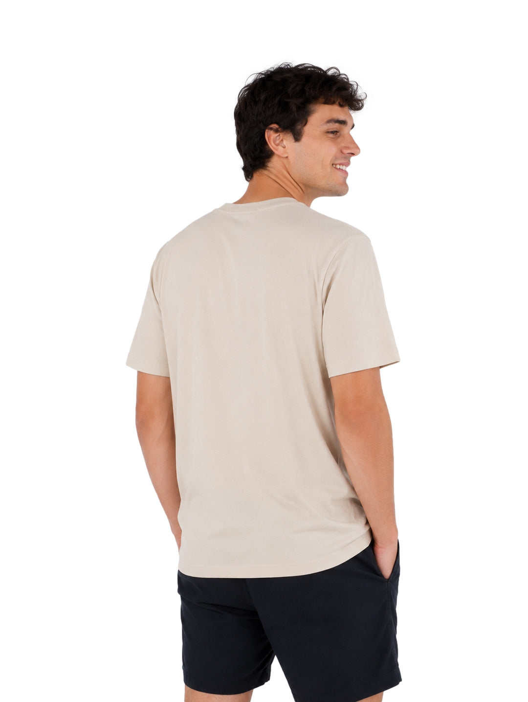 Hombre vistiendo playera Hurley de color hueso con cuello redondo y manga corta.