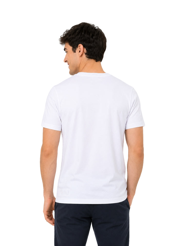 Hombre vistiendo una playera blanca de manga corta marca Hurley con un pequeño logo circular en el pecho.