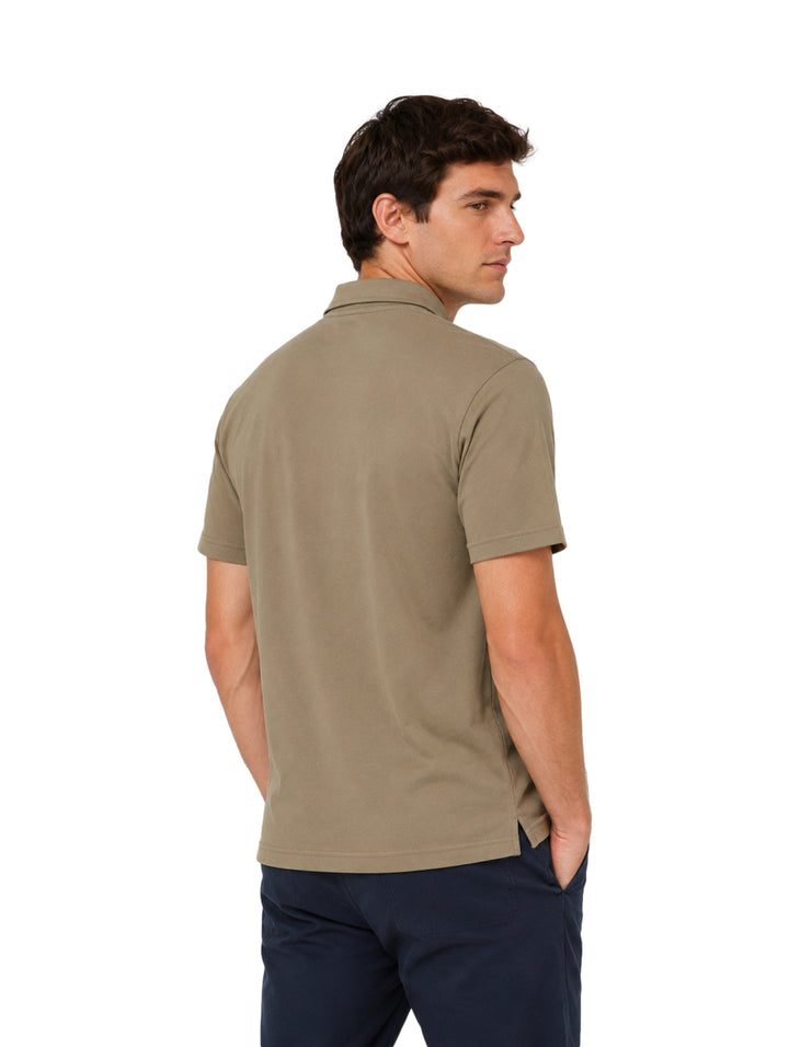 Hombre vistiendo playera polo Hurley color iguana de manga corta y cuello con botones.