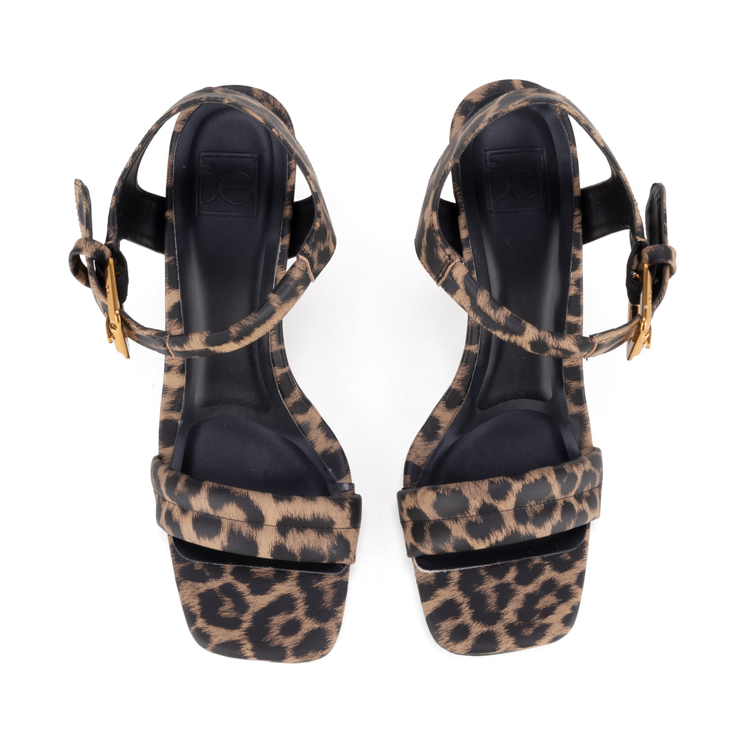 Sandalias de tacón alto con estampado de leopardo en marrón y negro y hebilla dorada.