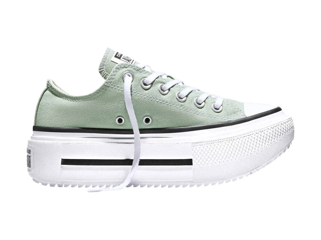 Tenis Converse color verde con suela de plataforma blanca y detalles en negro.