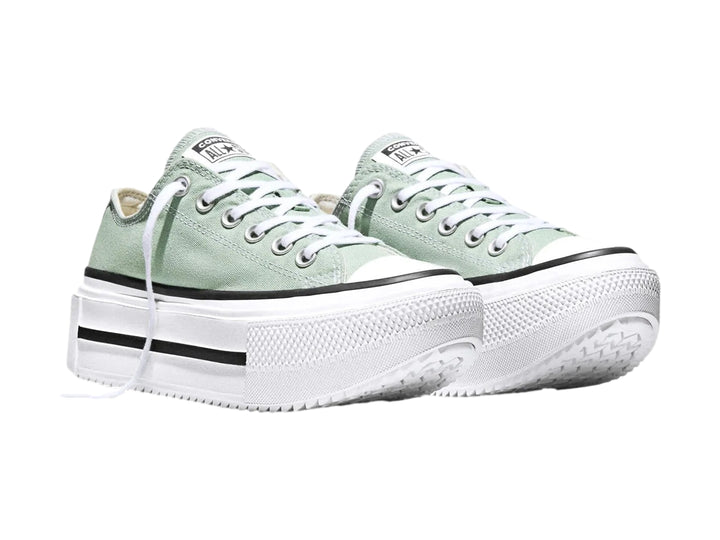 Tenis Converse color verde con suela de plataforma blanca y detalles en negro.