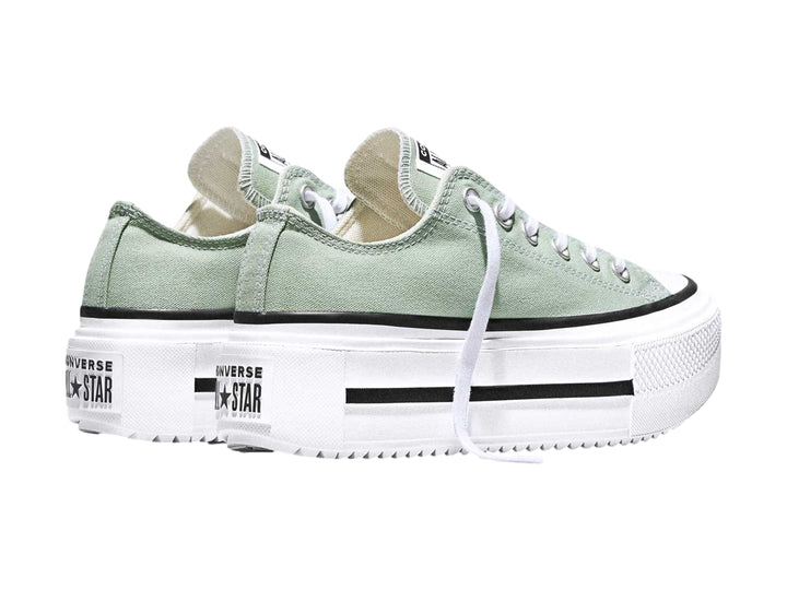 Tenis Converse color verde con suela de plataforma blanca y detalles en negro.
