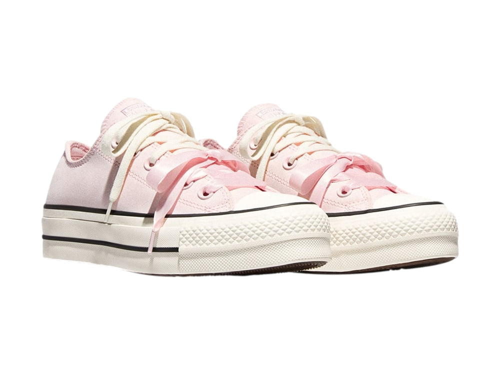 Tenis Converse de plataforma color rosa con suela blanca y franjas negras laterales.