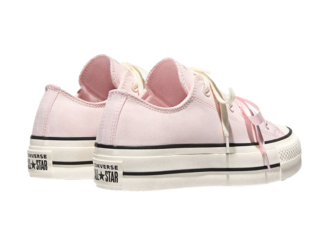 Tenis Converse de plataforma color rosa con suela blanca y franjas negras laterales.