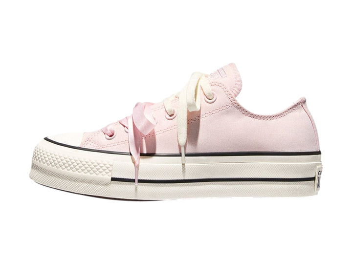 Tenis Converse de plataforma color rosa con suela blanca y franjas negras laterales.