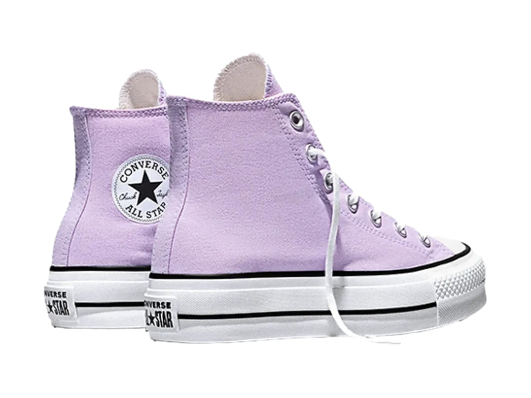 Tenis Converse de bota alta color lila con suela de plataforma blanca.