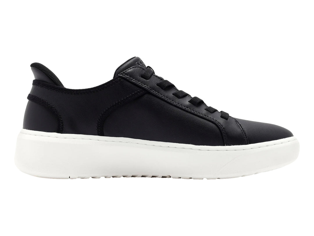 Tenis Skechers color negro con suela blanca gruesa y cordones negros.