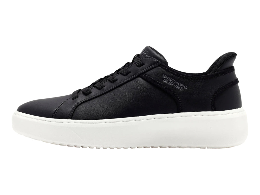 Tenis Skechers color negro con suela blanca gruesa y cordones negros.