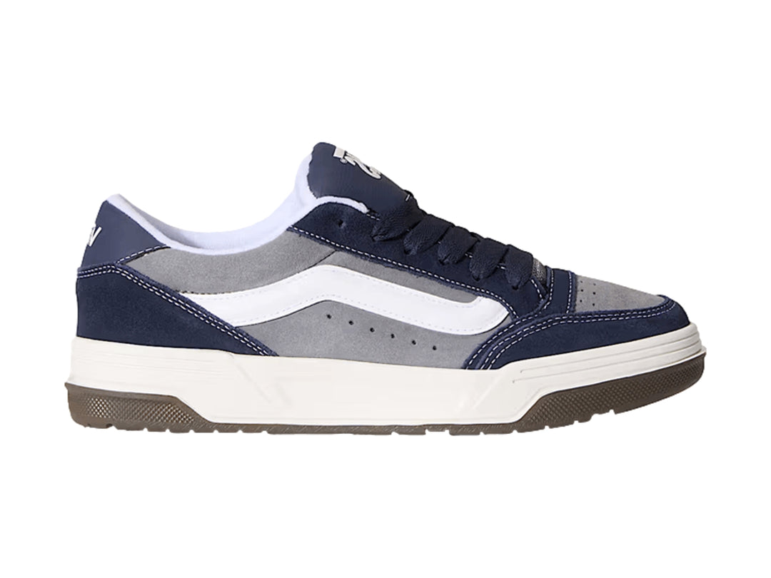 Tenis Vans Hylane en colores gris y azul marino con franja blanca y suela de goma marrón.