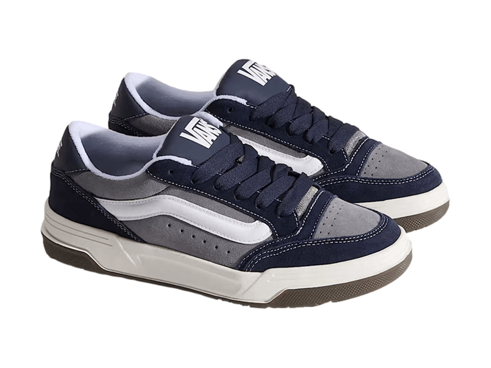 Tenis Vans Hylane en colores gris y azul marino con franja blanca y suela de goma marrón.