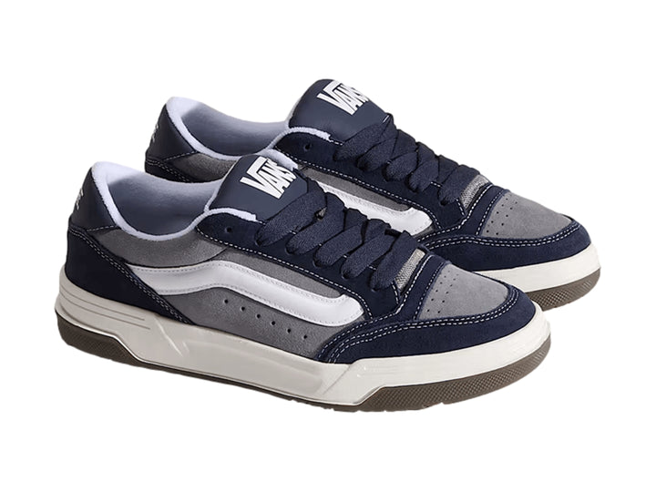 Tenis Vans Hylane en colores gris y azul marino con franja blanca y suela de goma marrón.